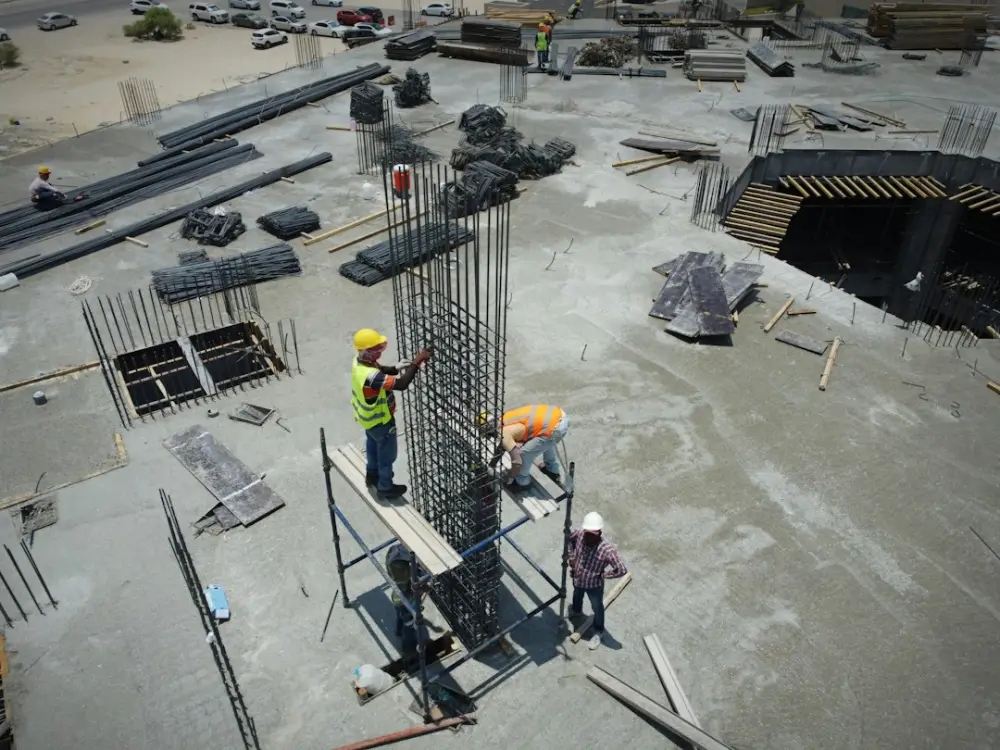 A group of men standing on top of a construction site, illustrating communication between field leaders and project managers